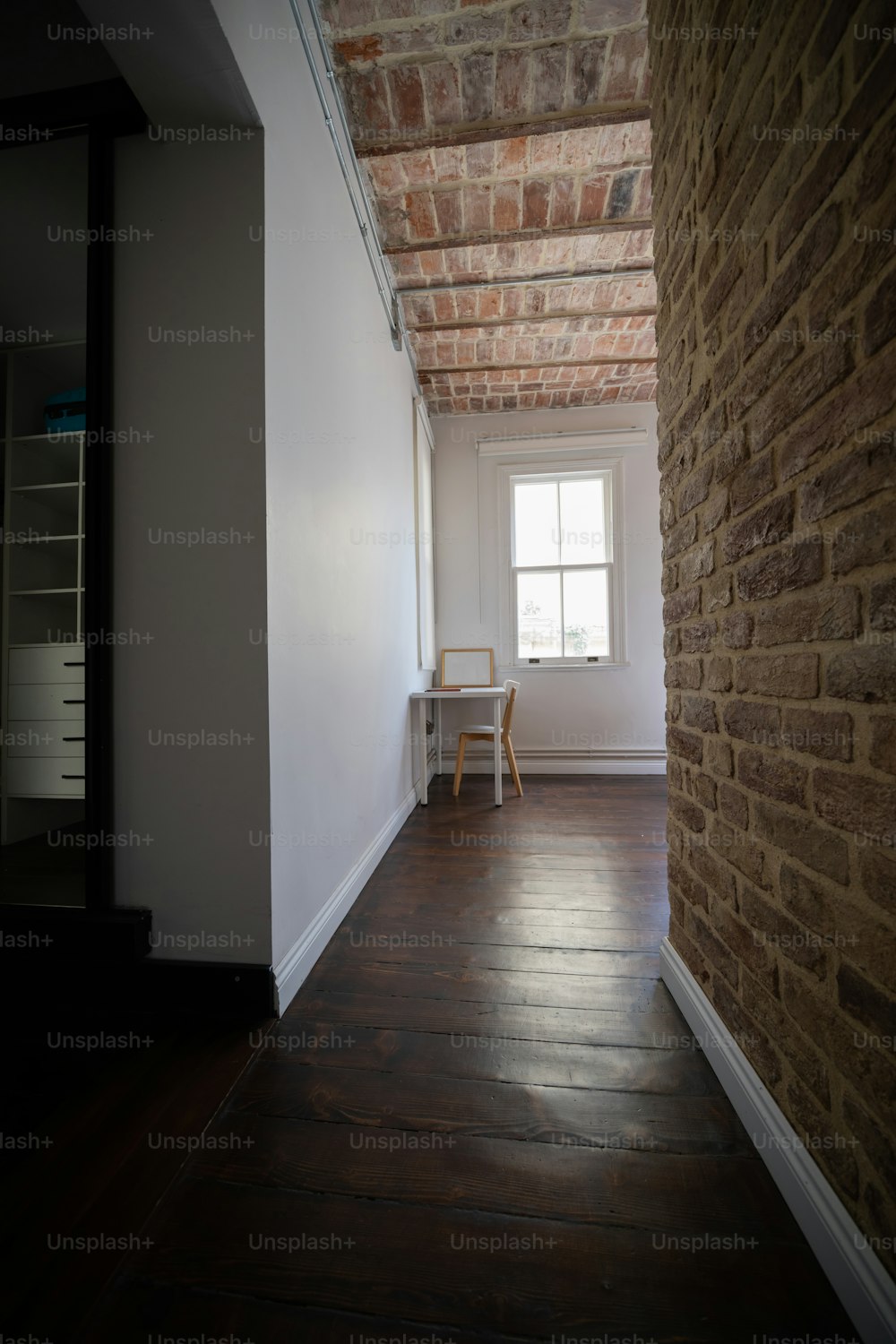 una habitación con una pared de ladrillo y suelos de madera