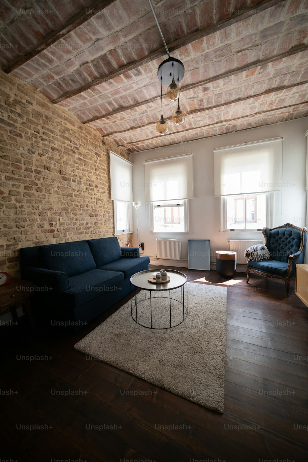 a living room filled with furniture and a brick wall