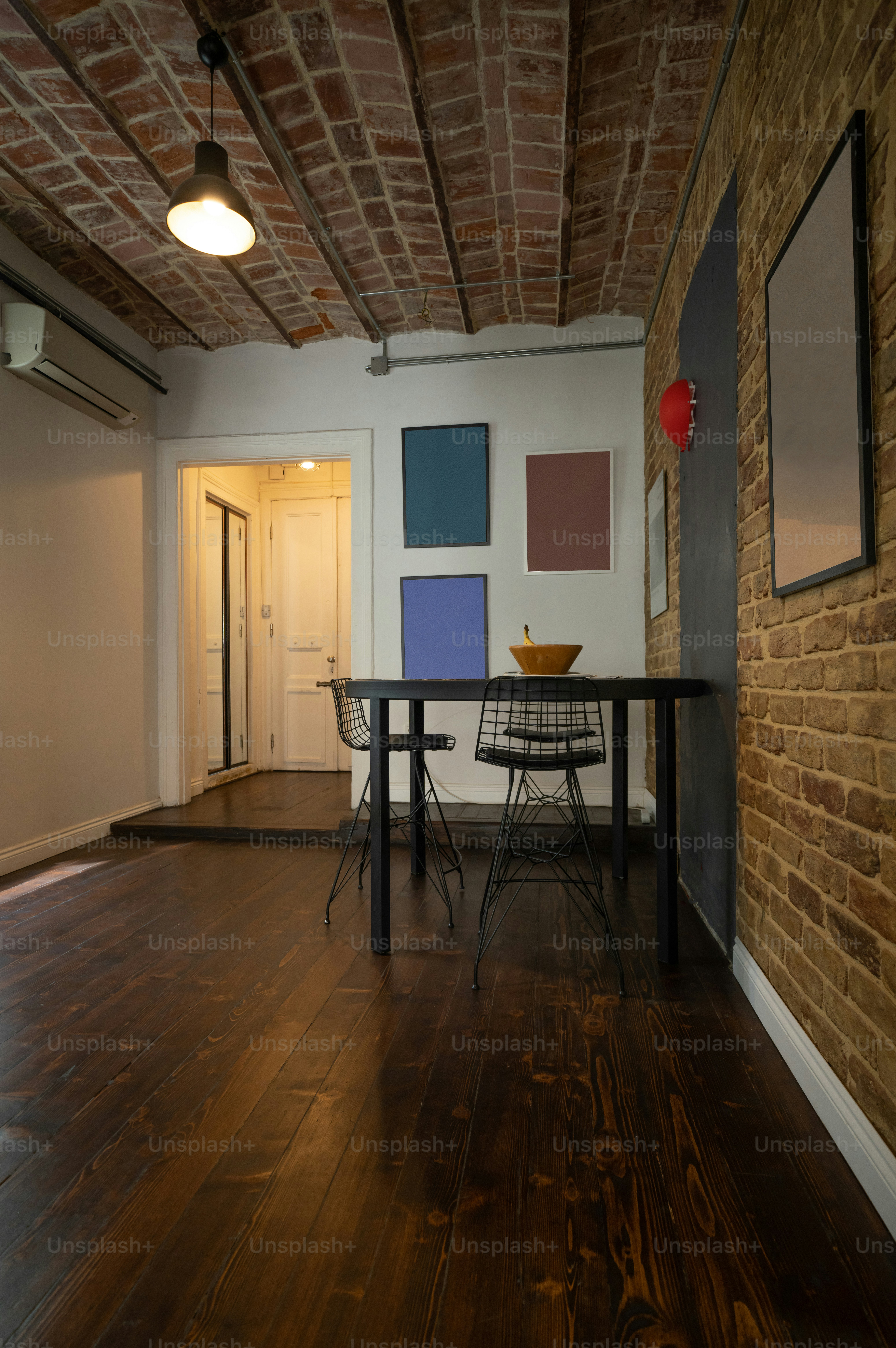 ein Raum mit Tisch, Stühlen und Bildern an der Wand