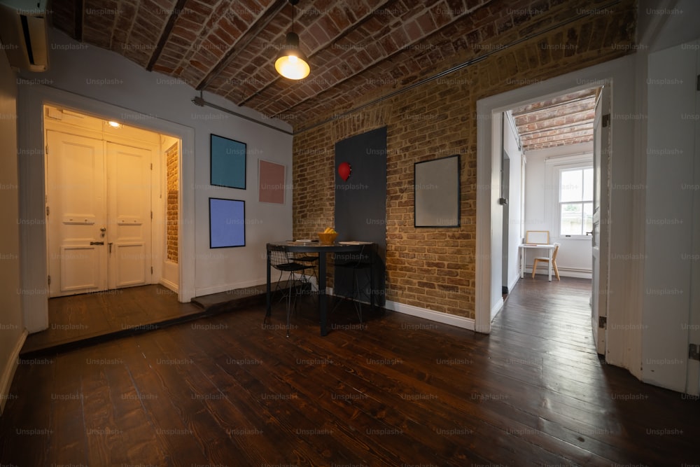 a room with a brick wall and wooden floors