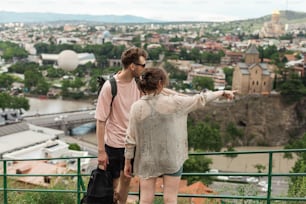 a man and a woman standing on top of a hill