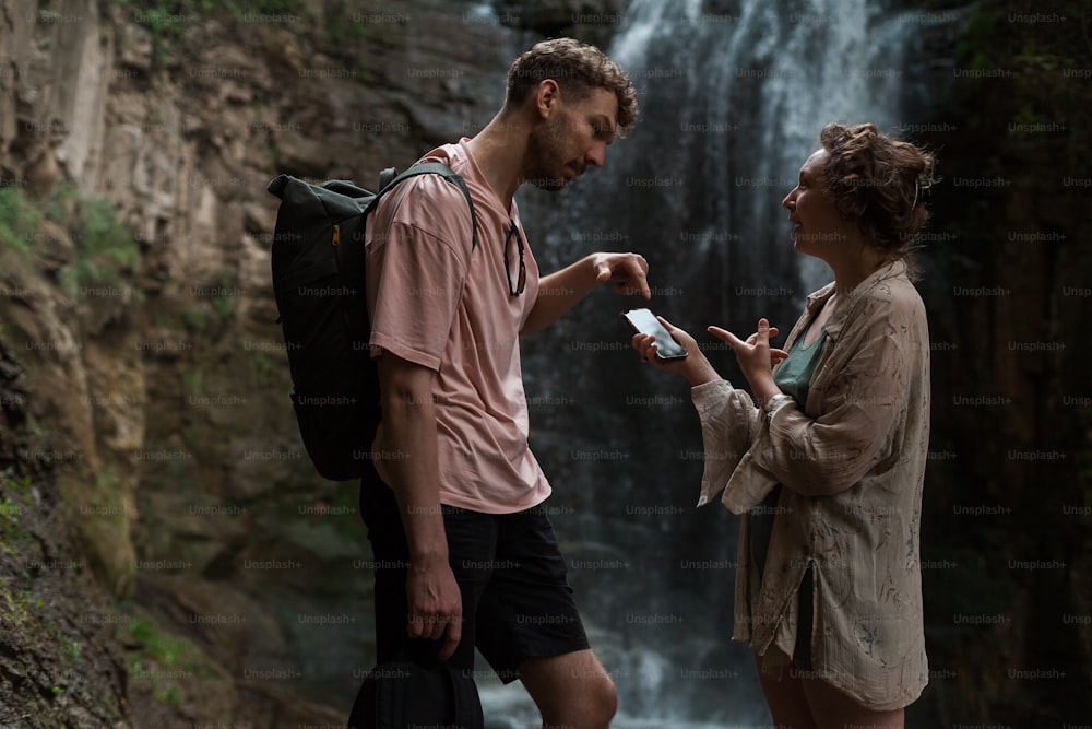 Un homme et une femme debout devant une cascade