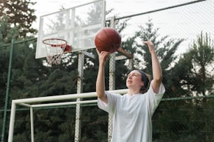 Un jeune homme tenant un ballon de basket en l’air