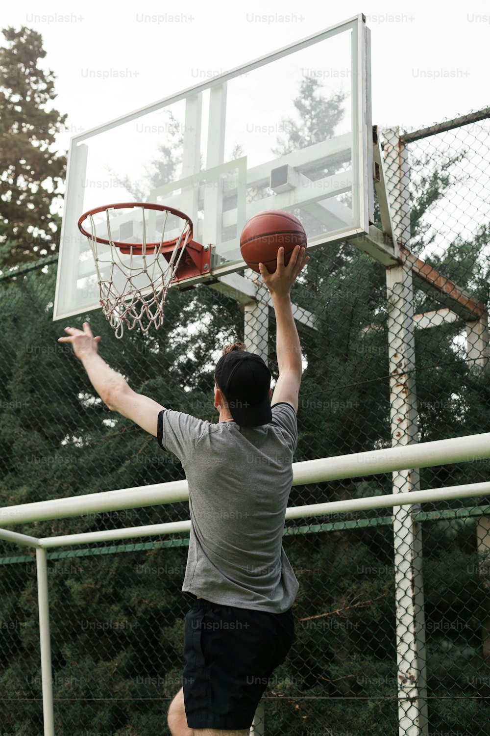 Un hombre sumergiendo una pelota de baloncesto en un aro de baloncesto