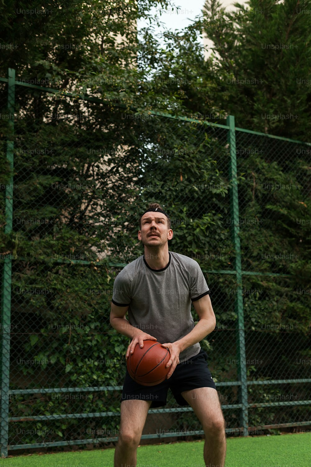 a man holding a basketball on top of a field