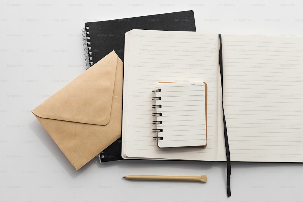 um caderno, caneta e envelope em uma mesa