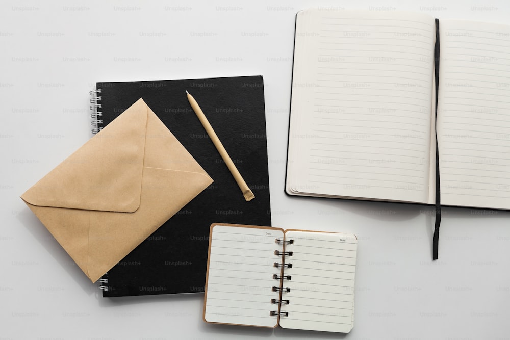 um caderno, caneta e envelope em uma mesa