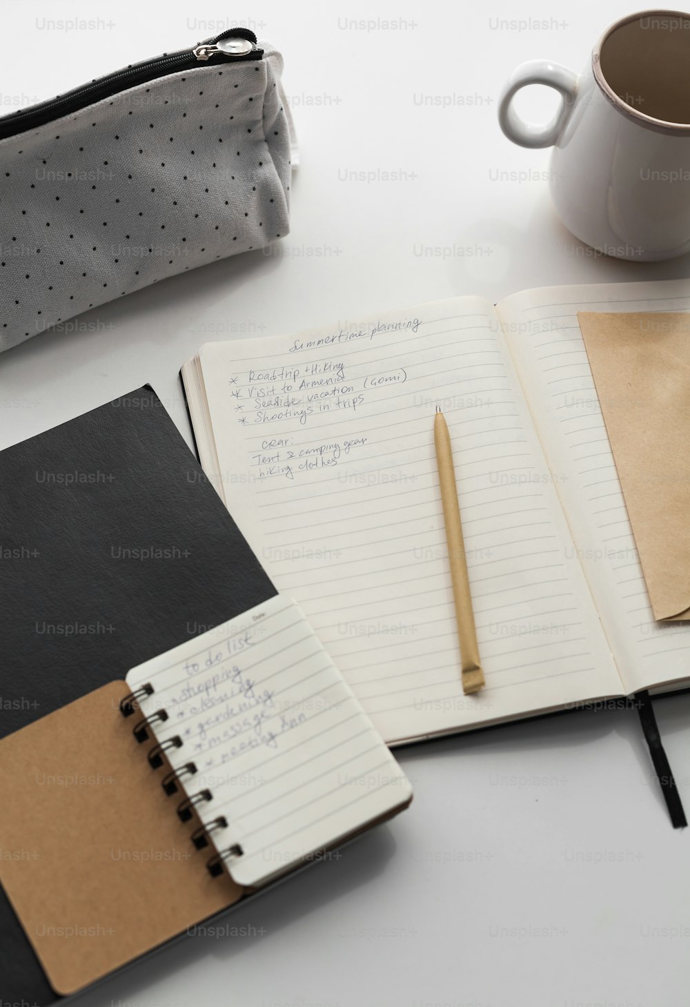 a notebook with a pen and a cup of coffee
