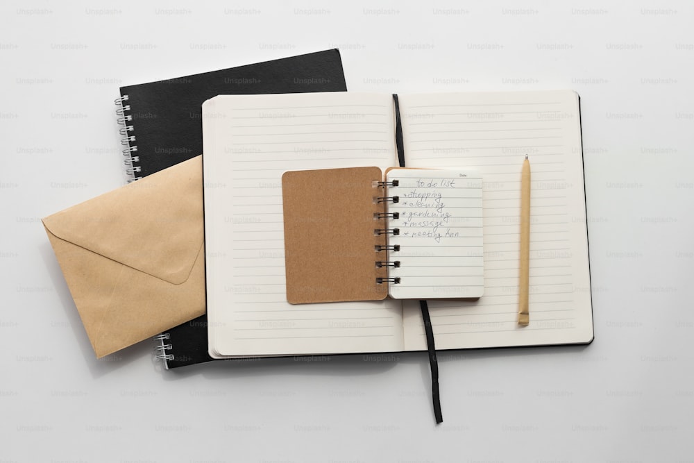 un cahier avec un bloc-notes, un stylo et une enveloppe