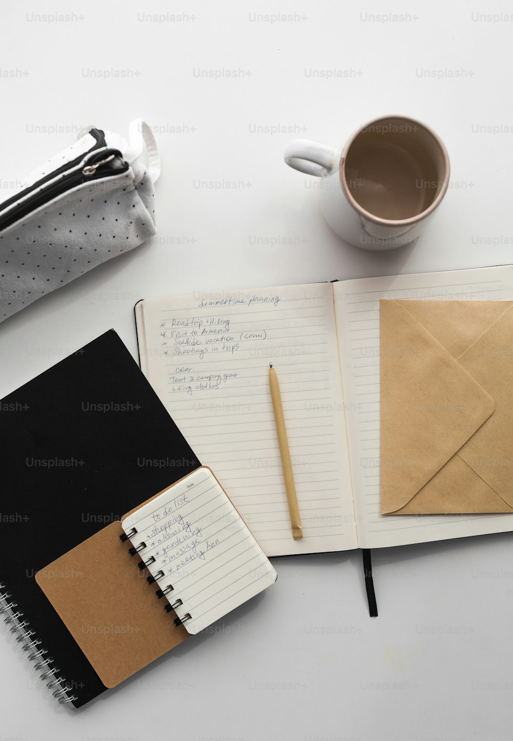 an open notebook with a pen and a cup of coffee