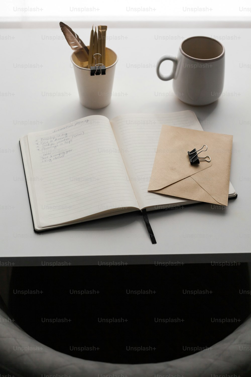 an open notebook sitting on top of a table next to a cup of coffee