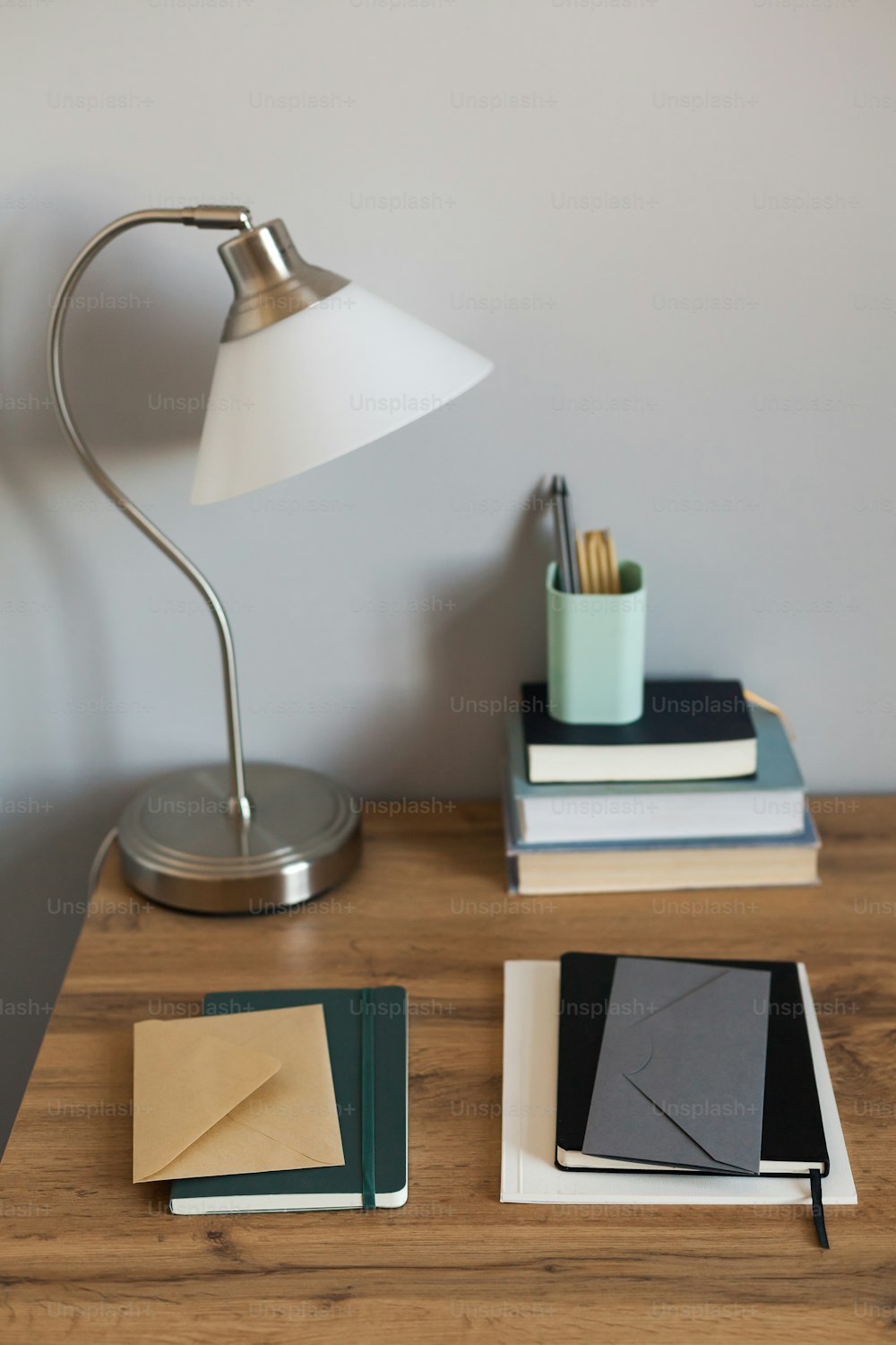 a desk with a lamp, books, and a phone on it