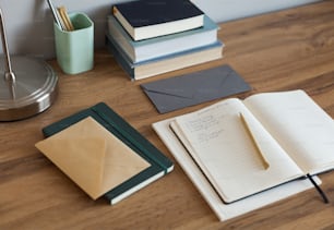 a wooden table topped with notebooks and papers