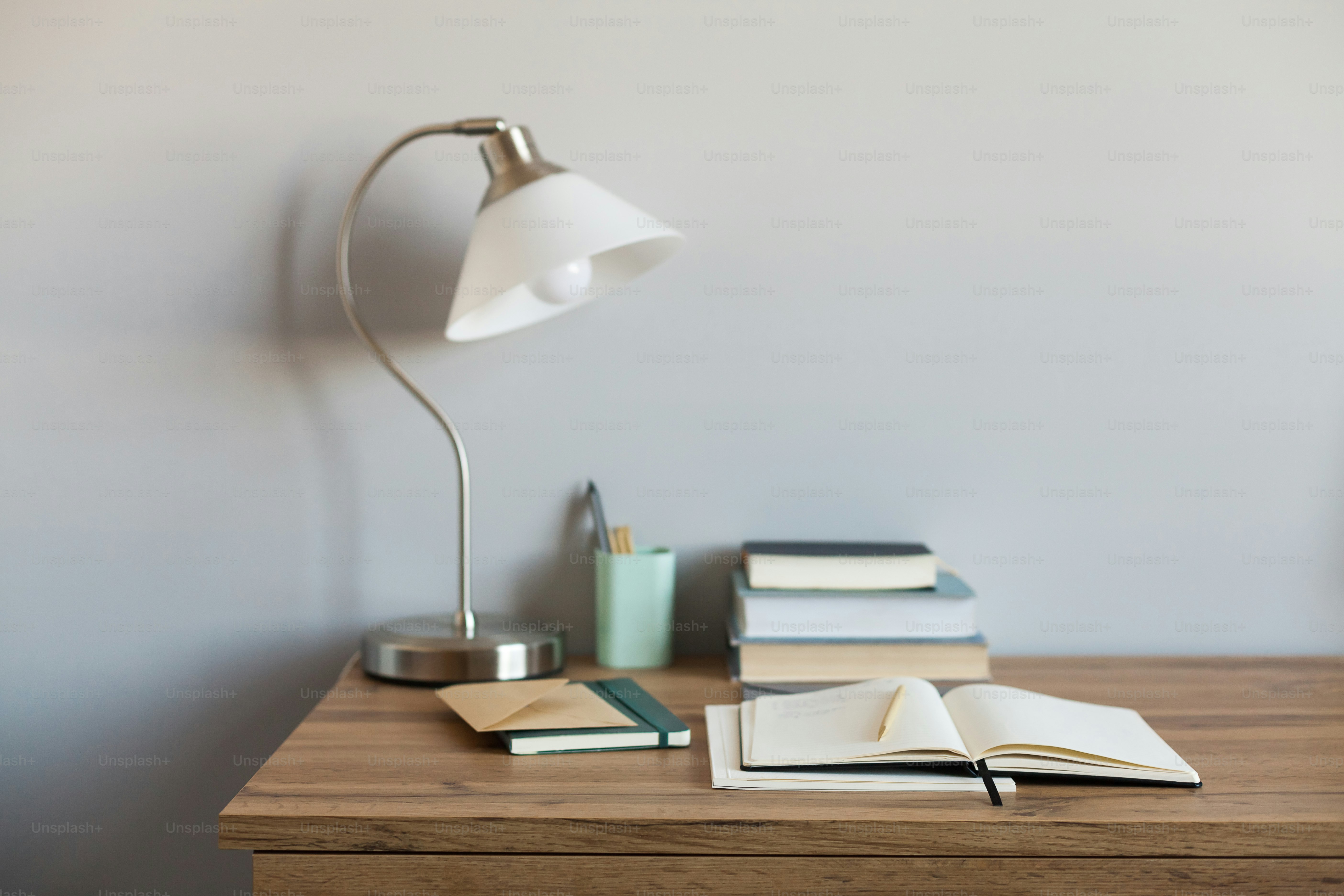 A desk with a lamp, books and a pen on it photo – Desk Image on Unsplash
