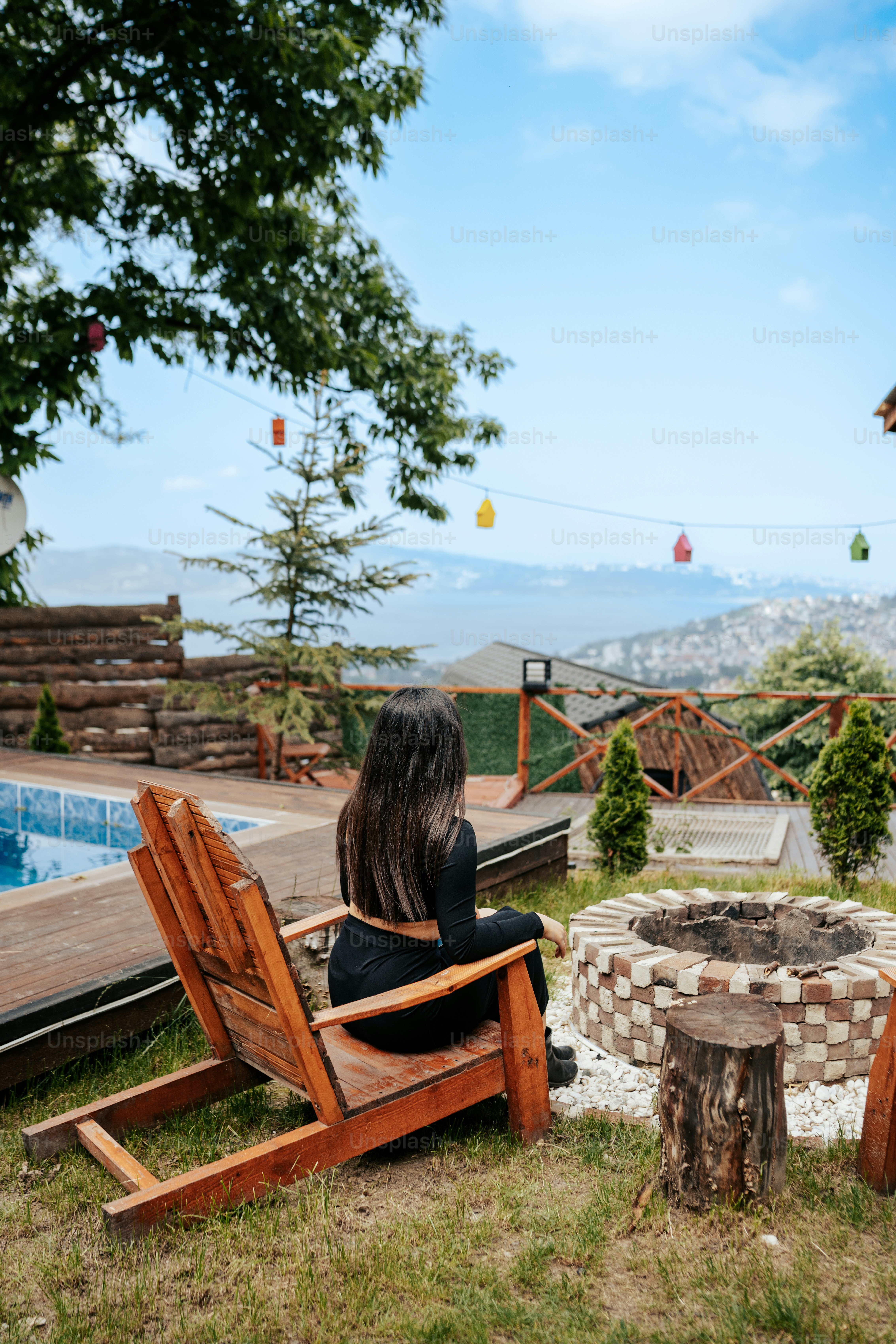 a woman sitting in a chair next to a fire pit