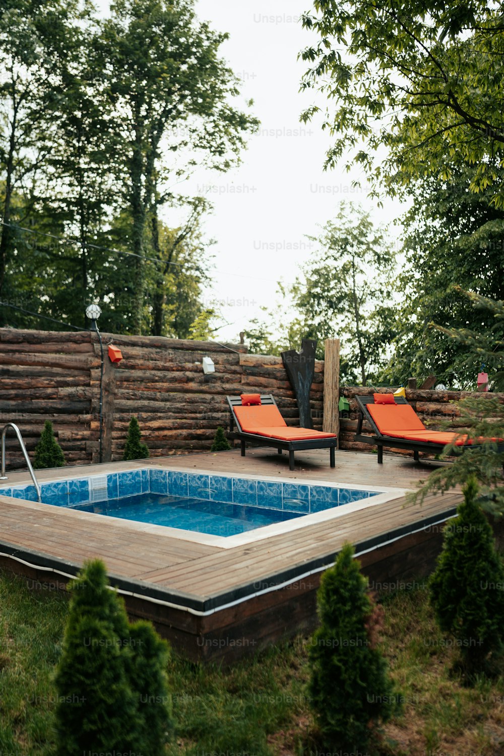 a backyard with a swimming pool and lounge chairs