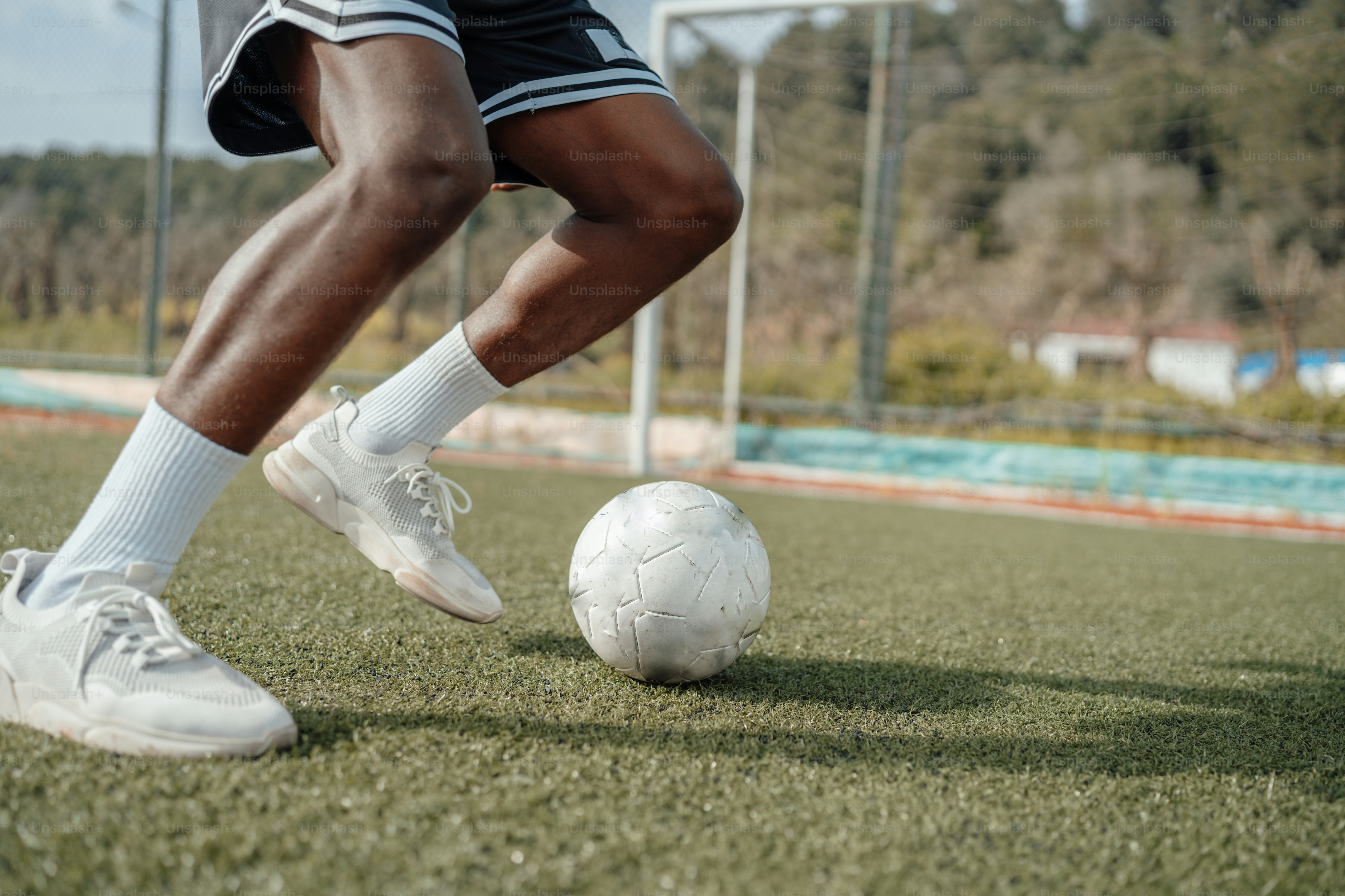 a man is kicking a soccer ball on the field
