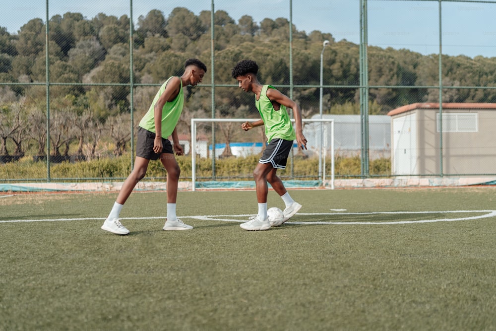 a couple of men standing on top of a soccer field