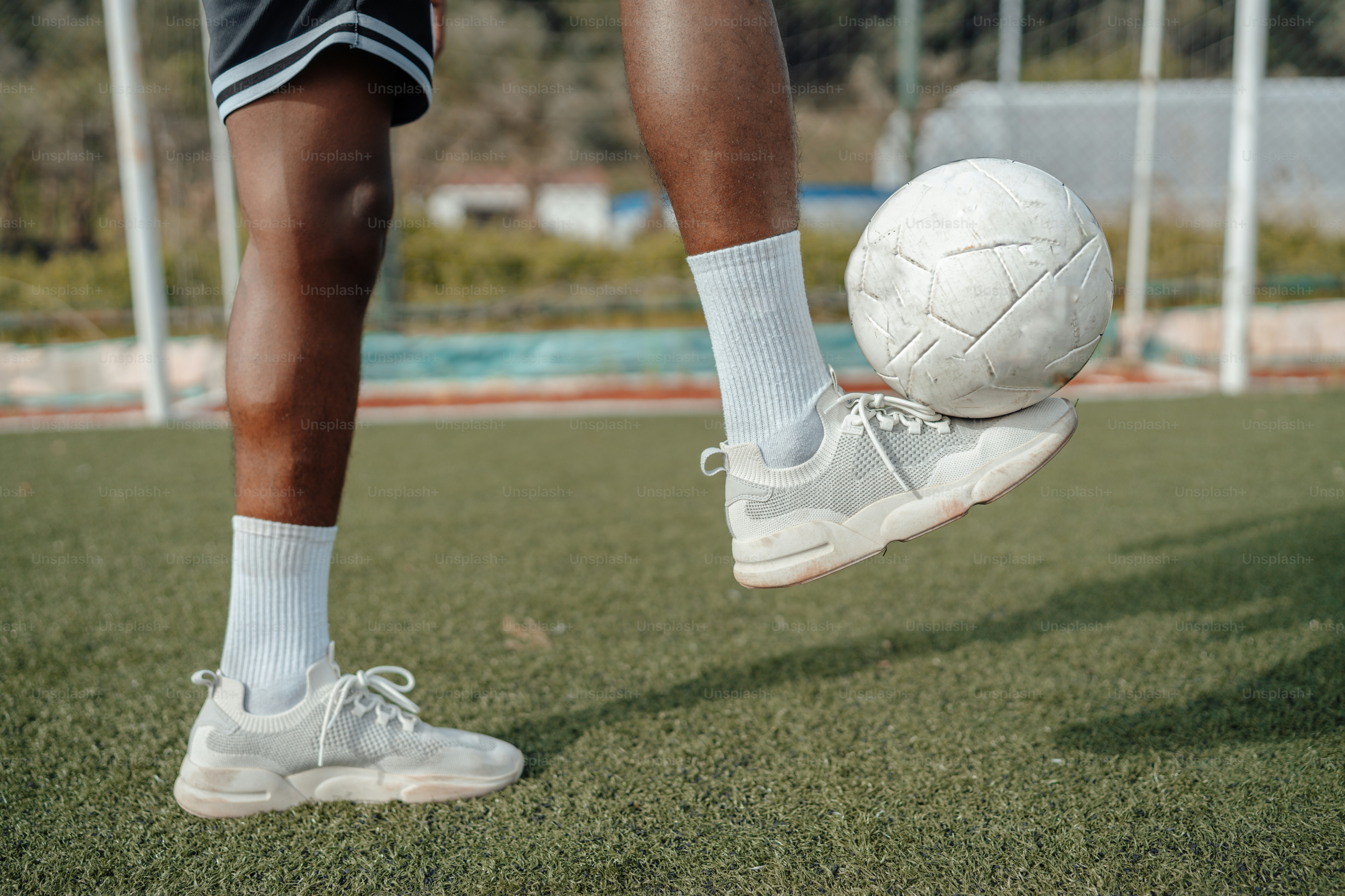 a person standing on top of a soccer ball on a field