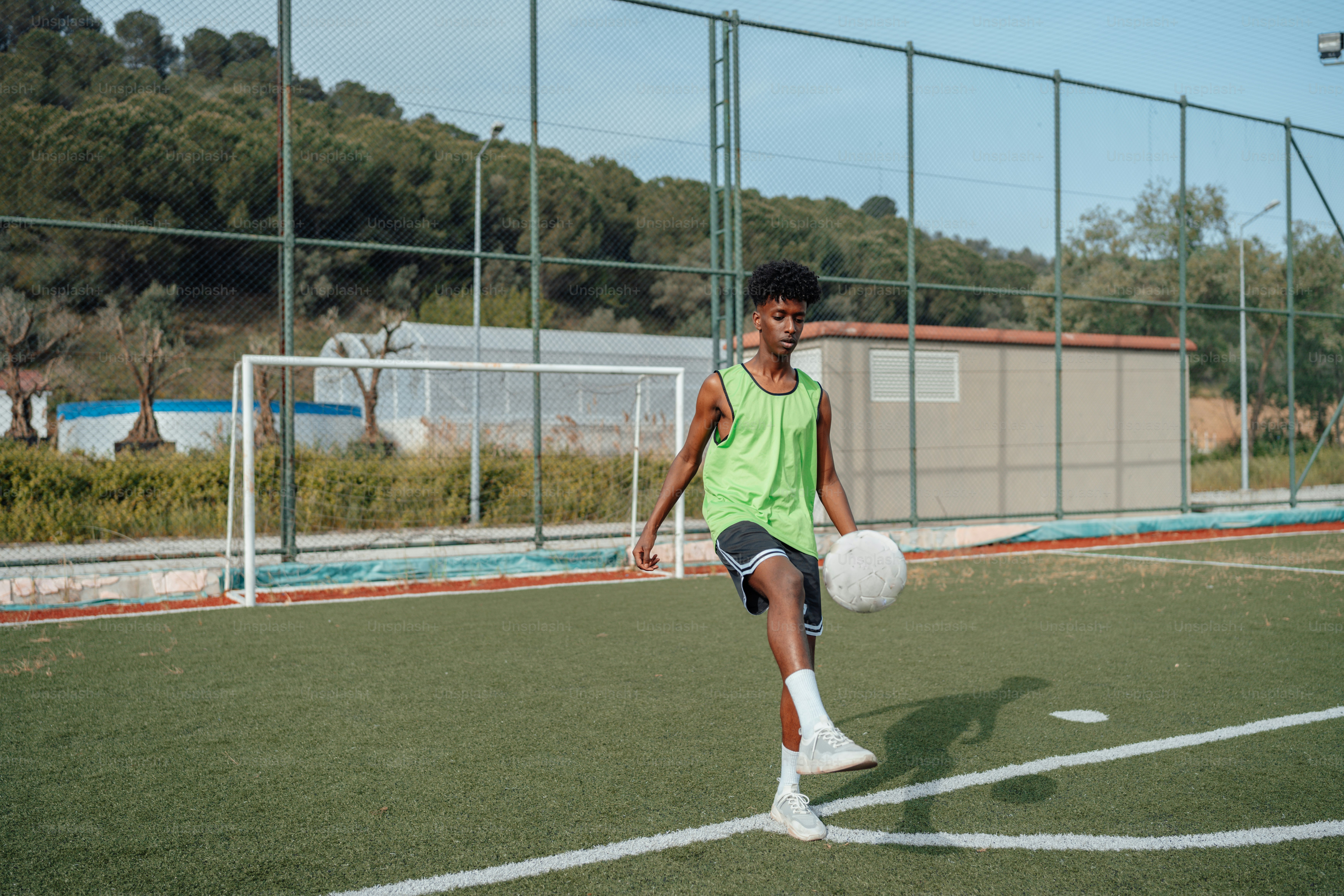 Seorang anak laki-laki menendang bola sepak di lapangan
