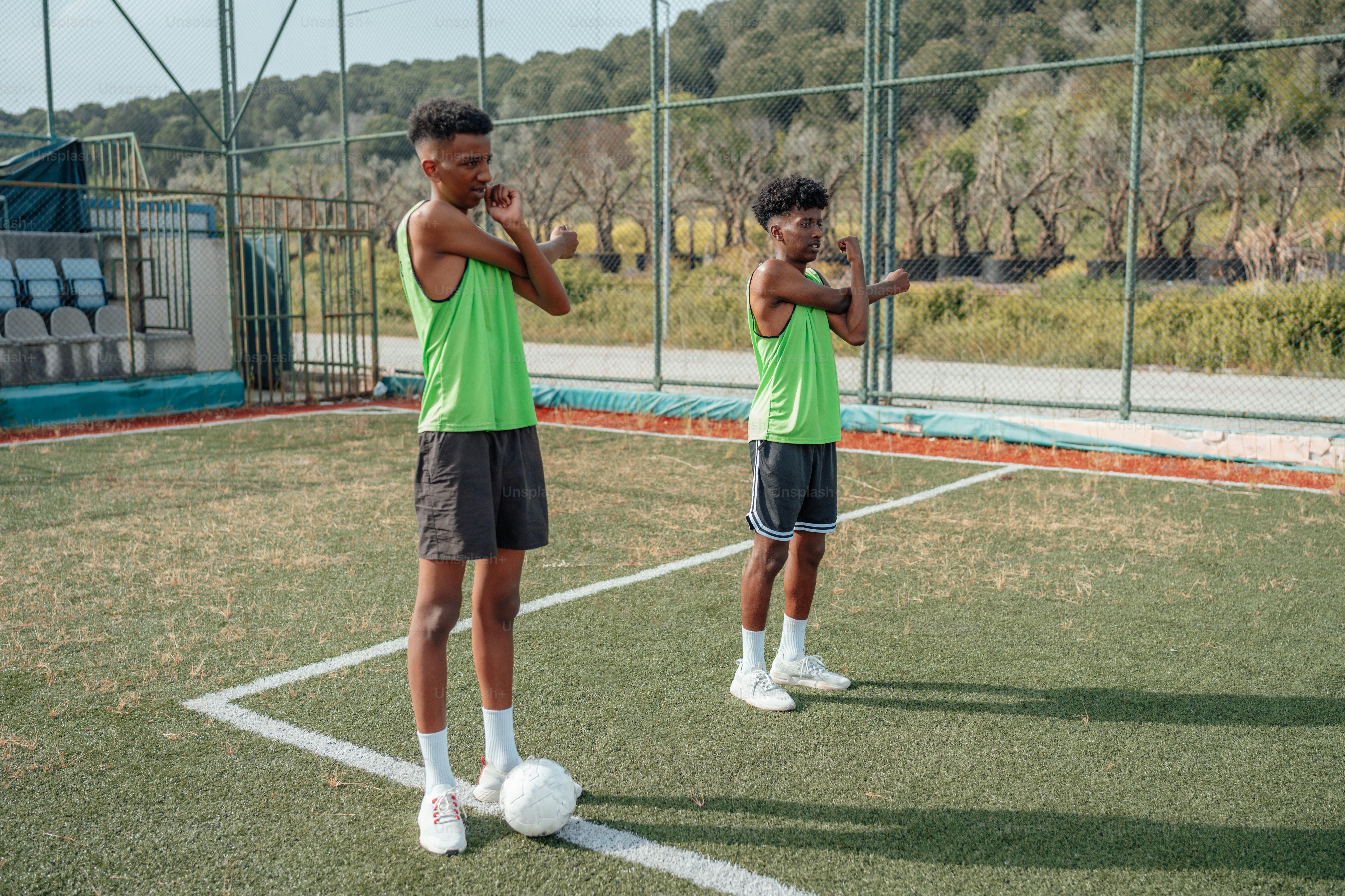 a couple of young men standing on top of a tennis court