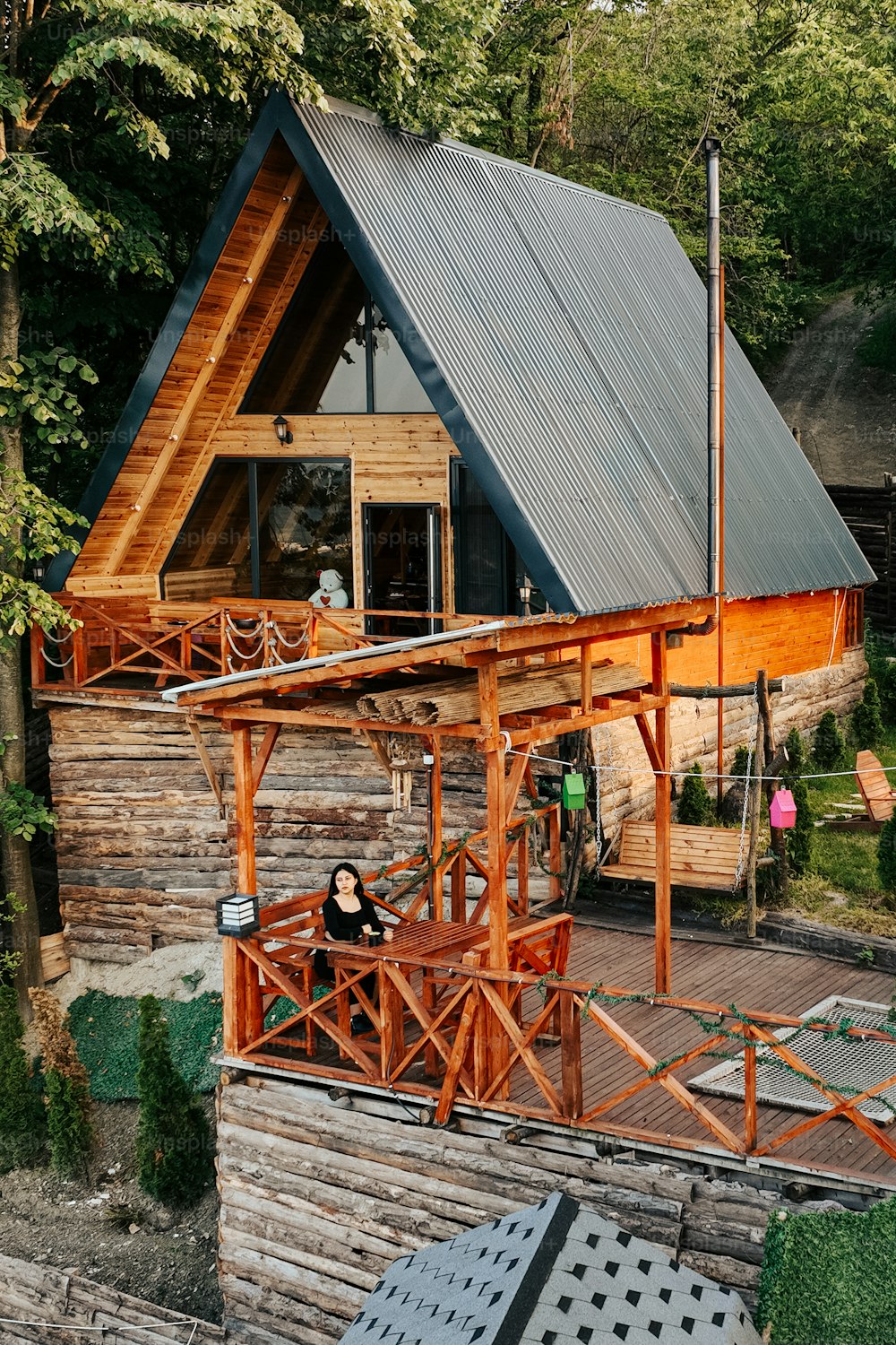 a wooden cabin with a metal roof in the woods