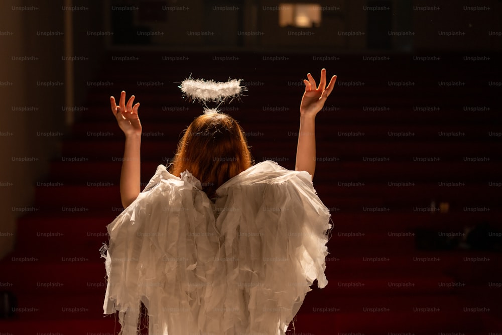 a woman in a white dress standing in front of a stage