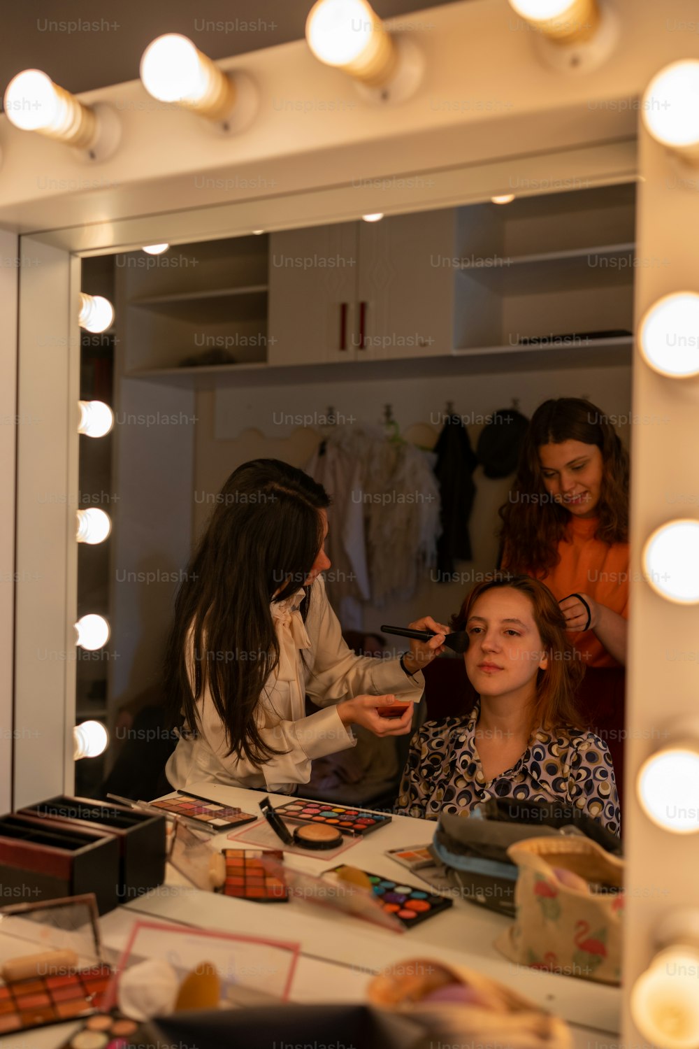 鏡の前で髪を整えている女性