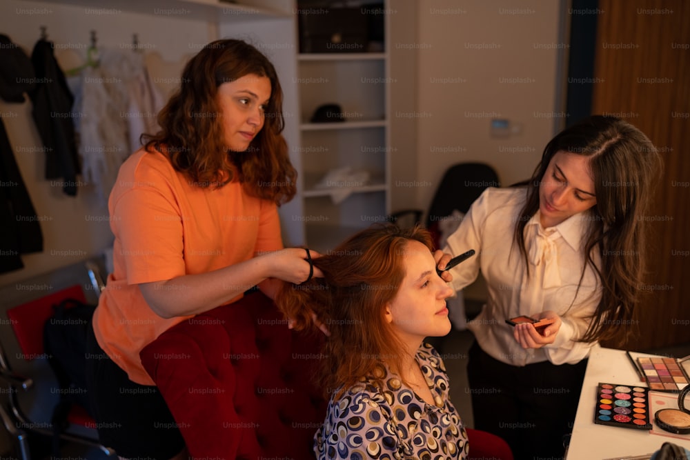 a woman getting her hair styled by another woman