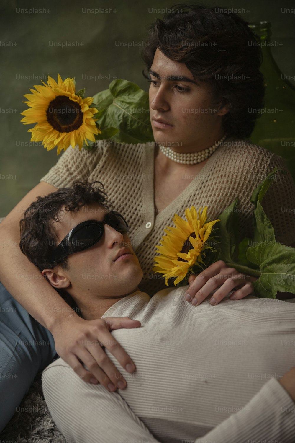 a man laying on top of a woman with a sunflower