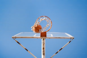 Una pelota de baloncesto pasando por el aro en un día despejado
