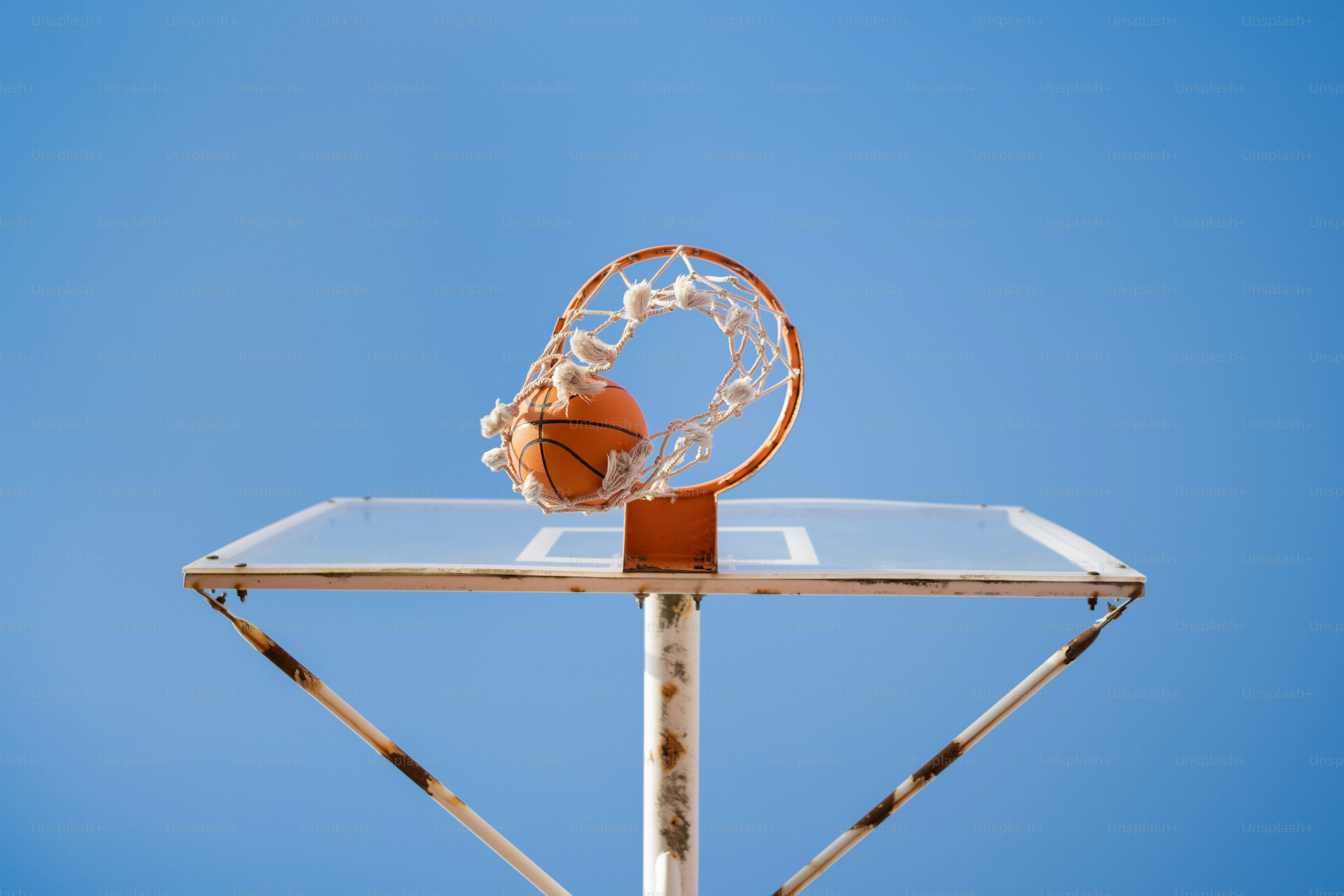 a basketball going through the hoop on a clear day