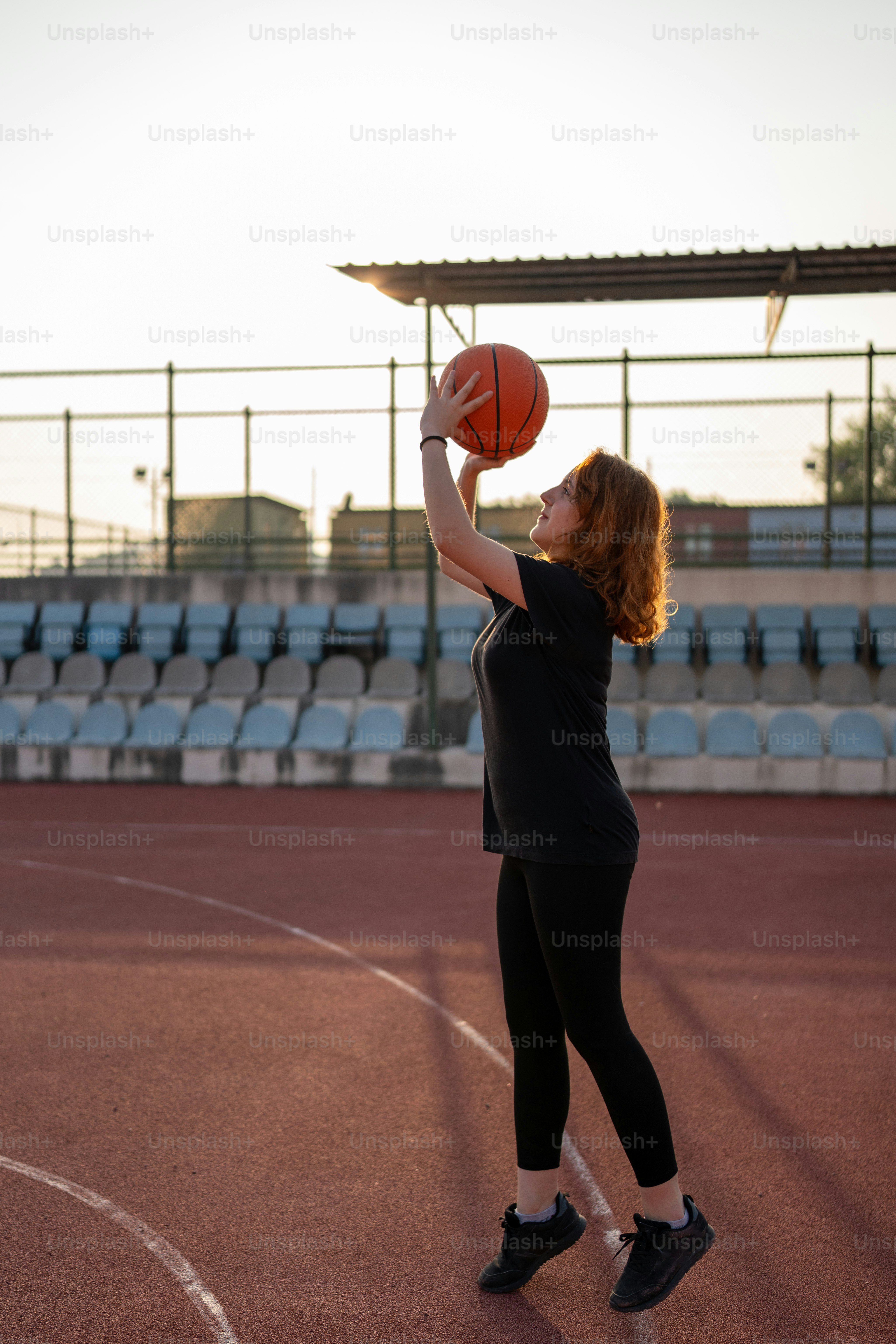 a woman holding a basketball on a basketball court