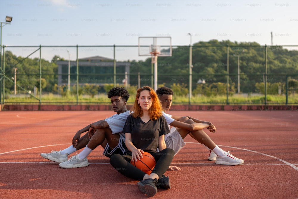 a group of people sitting on a basketball court