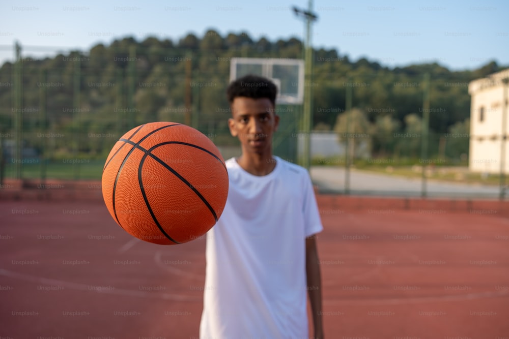 a young man holding a basketball on a court