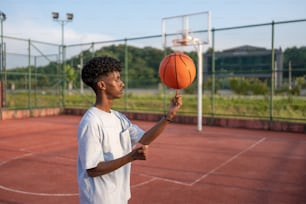 a young man holding a basketball on a court