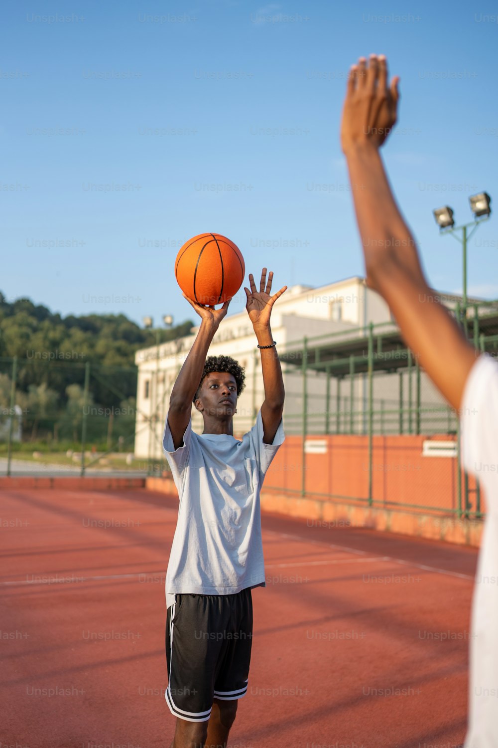 two young men are playing basketball on a court
