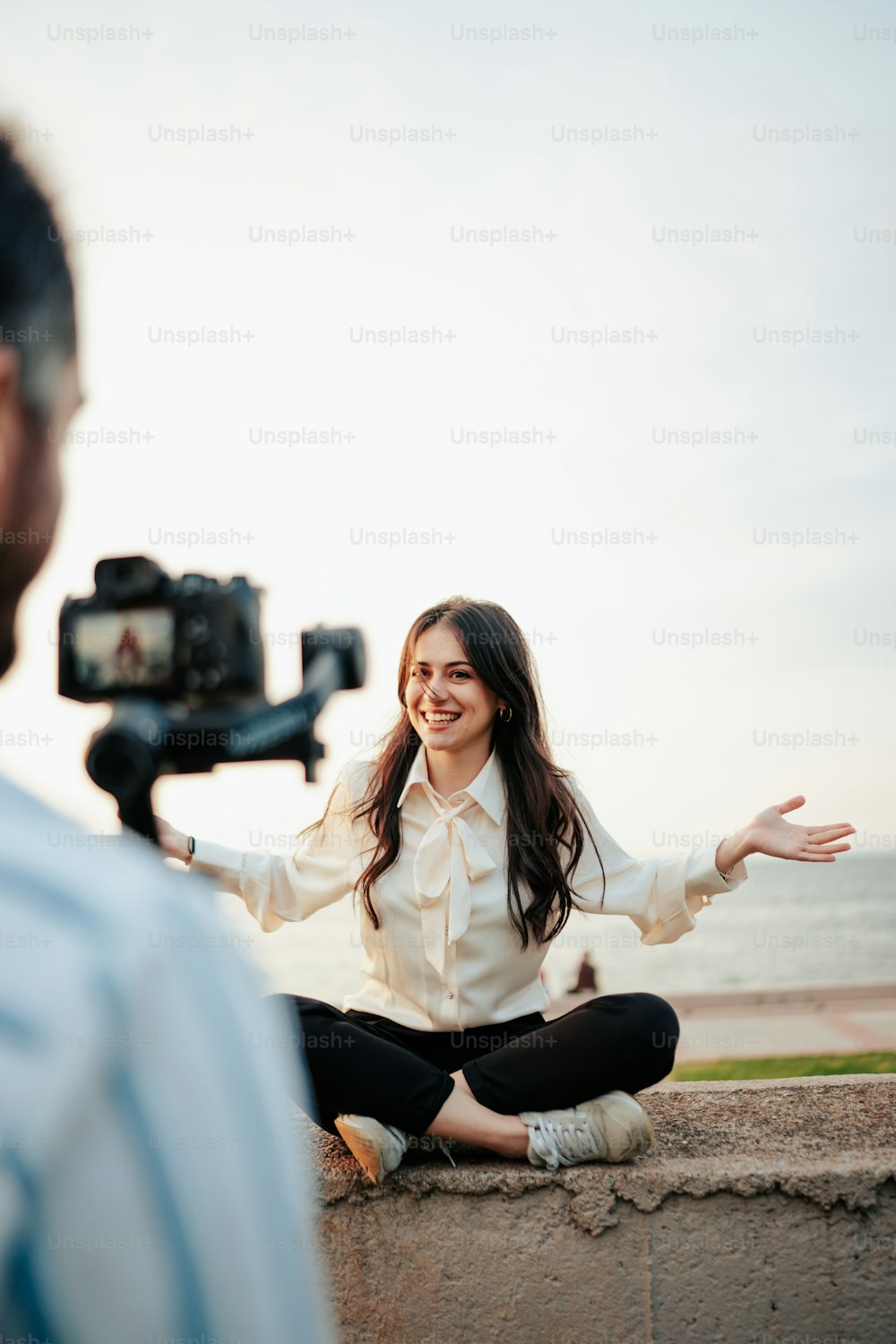 a woman sitting on the ground in front of a camera