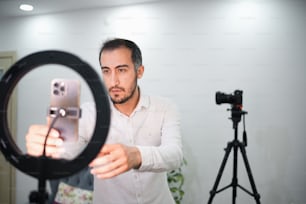 Un uomo che tiene una macchina fotografica davanti a uno specchio
