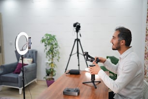 a man sitting at a table in front of a camera