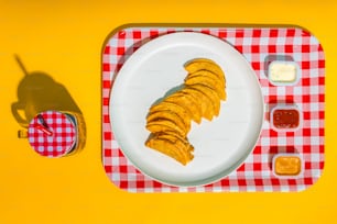 a plate of food on a red and white checkered table cloth
