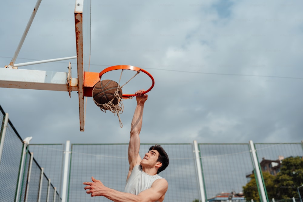 Un hombre sumergiendo una pelota de baloncesto en un aro