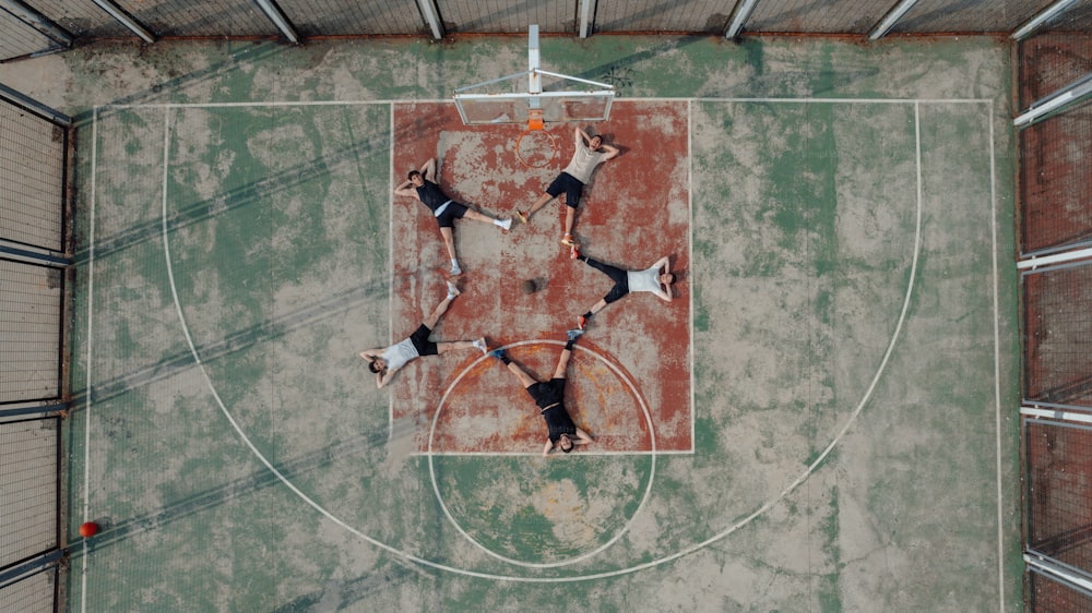 a group of people standing on top of a basketball court
