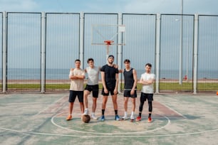 a group of men standing on top of a basketball court