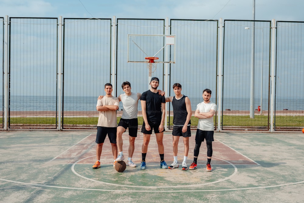 a group of men standing on top of a basketball court