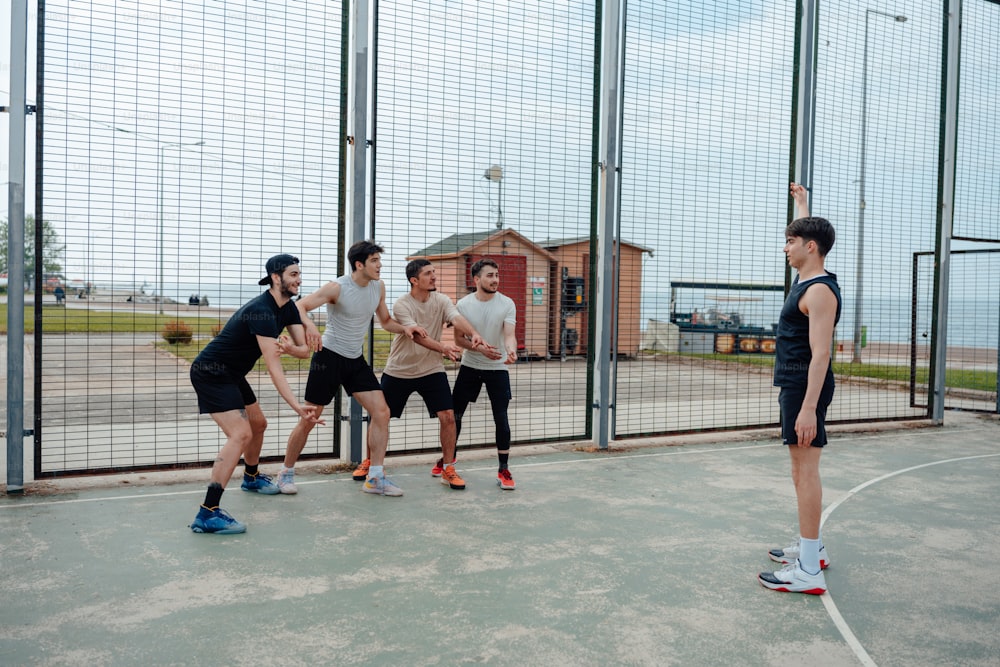 a group of men standing on top of a basketball court