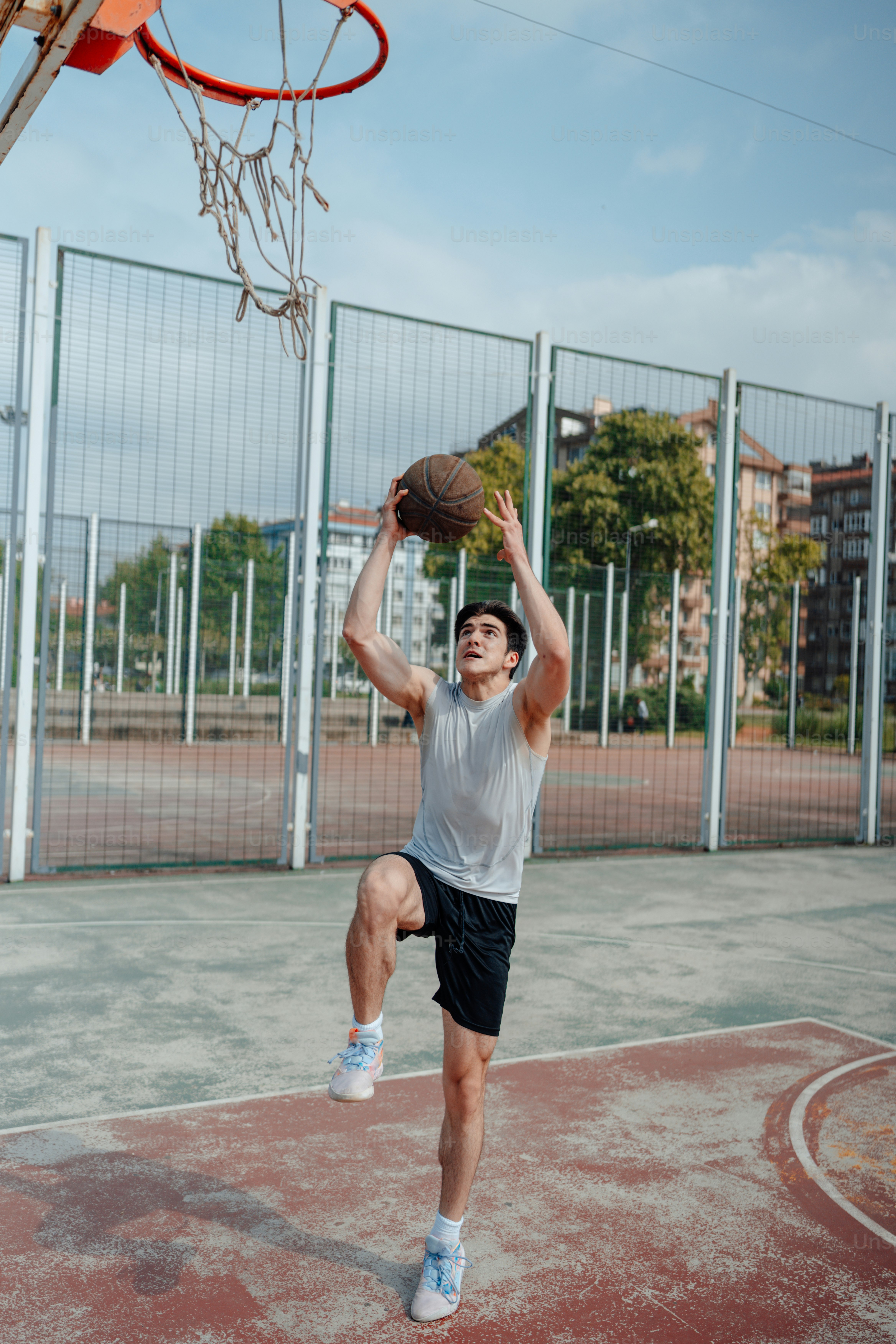 Seorang pria sedang bermain bola basket di lapangan