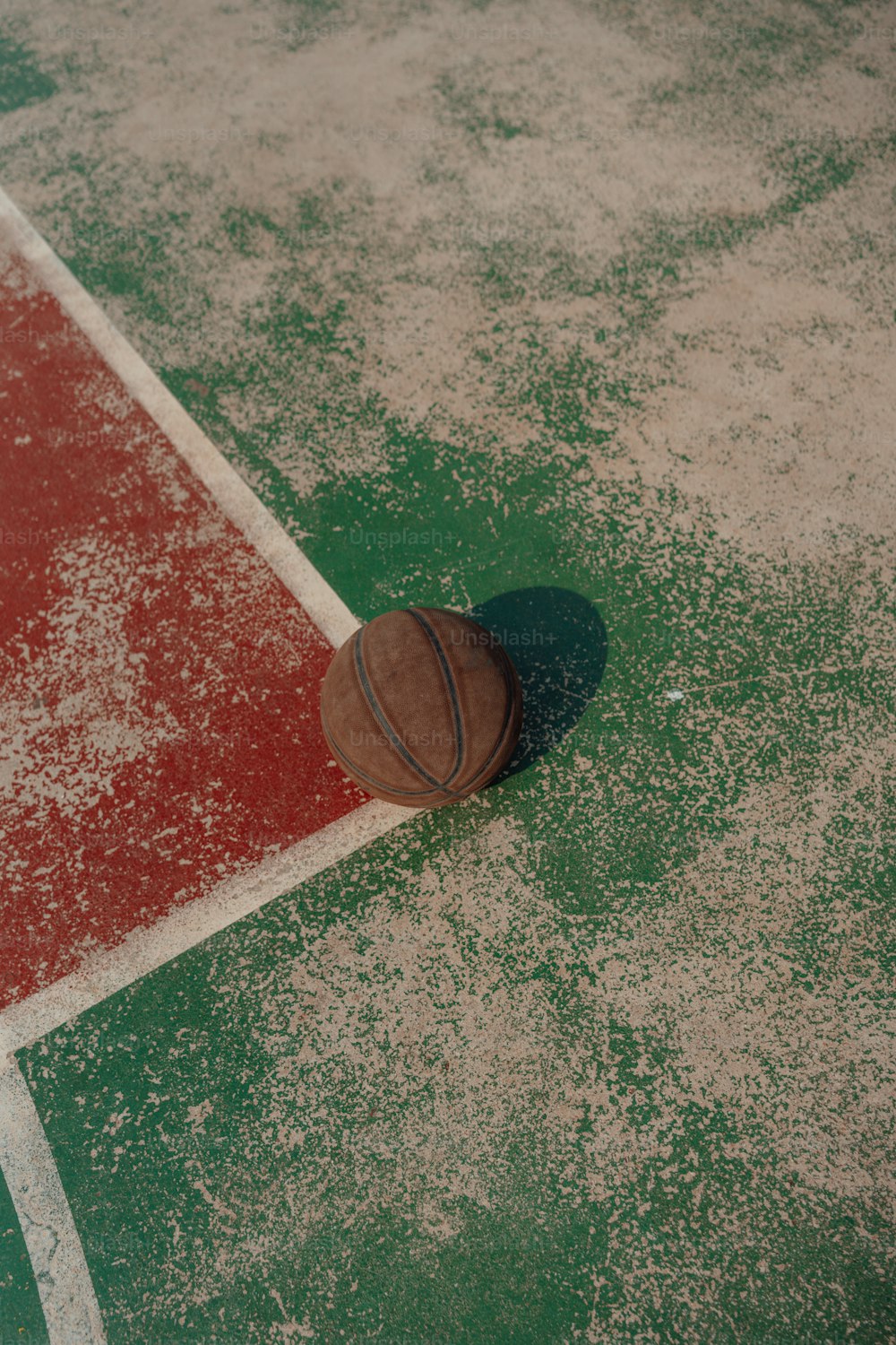 Una pelota de baloncesto tendida en el suelo de una cancha de baloncesto