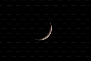 a crescent moon is seen in the dark sky