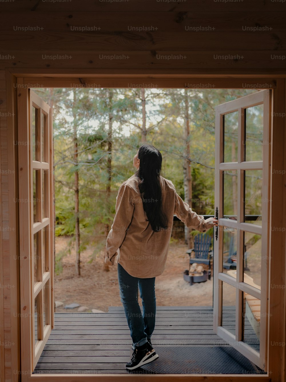 a woman walking out of a wooden door